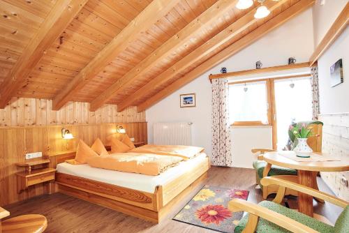 柯尼希斯湖畔舍瑙Landhaus Maltermoos的一间卧室设有一张床和木制天花板