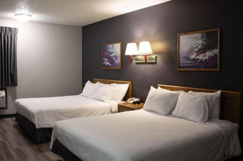 诺福克诺福克新维多利亚套房酒店 的酒店客房,配有两张带白色床单的床