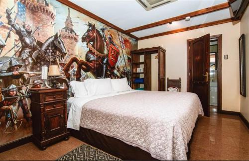 维纳德马卡斯蒂略中世纪酒店的卧室配有一张大床,墙上挂有绘画作品