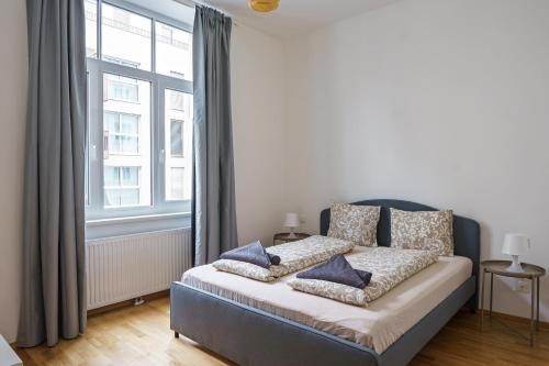 维也纳Vienna Living Apartments - Ottakring的一间卧室配有一张带蓝色枕头的床。