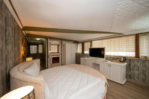 伊斯坦布尔Fuat Bey Palace Hotel & Suites的一间卧室配有一张床和一台电视。