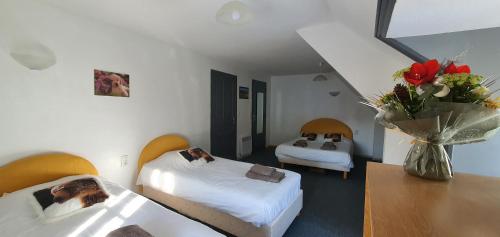CheyladeGrand Hotel de la Vallée的酒店客房带两张床和花瓶