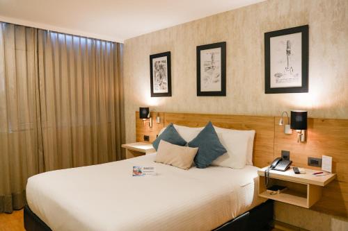 库库塔Hotel Casino Internacional的配有一张大床和一部电话的酒店客房