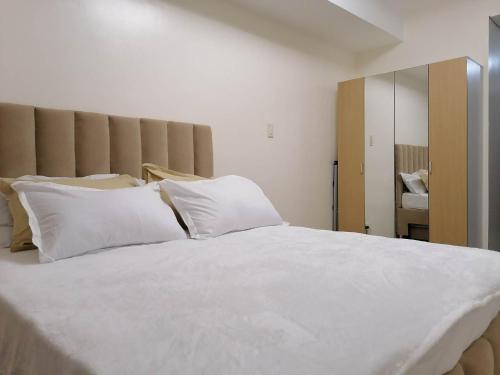 马尼拉Fast Wifi 400 Mbps at Kasara Urban Resort Residences with Netflix and Pool Access的卧室配有白色的床铺和白色的枕头