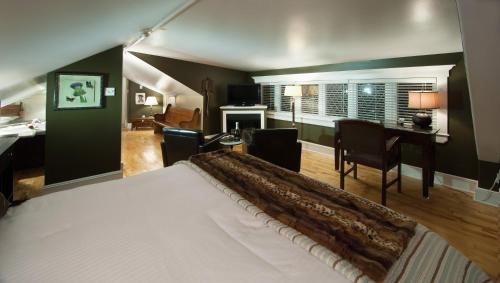 圣约翰斯李塞德庄园酒店的一间卧室配有一张床,客厅配有书桌