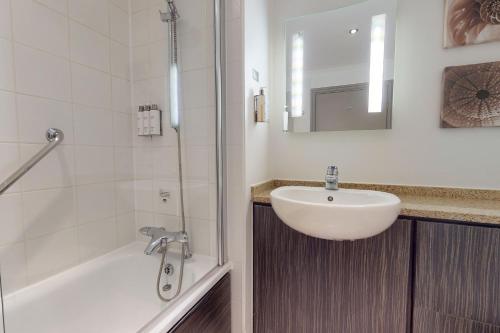 赫尔赫尔乡村酒店的浴室配有盥洗盆、浴缸和盥洗盆