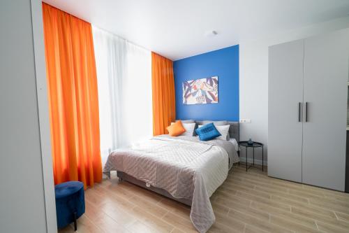 基辅MYFREEDOM Апартаменти метро Нивки的一间卧室配有橙色和蓝色墙壁的床