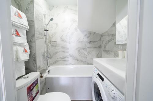 基辅MYFREEDOM Апартаменти метро Нивки的浴室配有卫生间水槽和洗衣机。