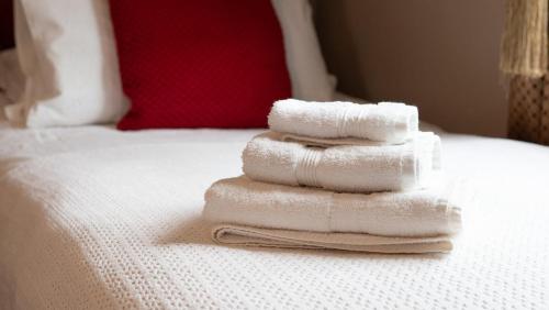 基尤Maids Guest Rooms的三条毛巾堆在床上
