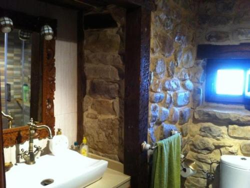 Arenas de IguñaEl Limonero的一间带水槽和石墙的浴室