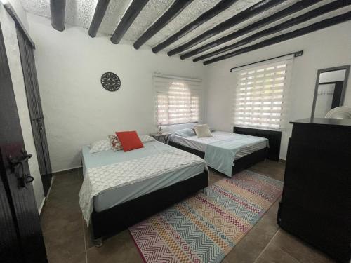梅尔加Casa de Descanso的带两张床和两个窗户的房间