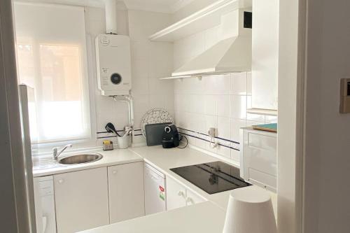 奇克拉纳－德拉弗龙特拉Novo Sancti Petri, La Barrosa, 2 Beds Room Apartamento by Chiclana Dreams的白色的厨房配有白色橱柜和水槽