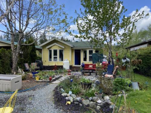 考伊琴湖Beaver Lake Resort Site #36的黄色房子前面的花园