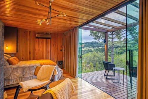 乌鲁佩马Refúgio de Altitude的一间卧室设有一张床和一个美景阳台