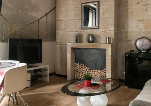 图尔"L'Appart" Vieux Tours - Charme - Place Plumereau - Arrivée Autonome的客厅设有壁炉和电视。
