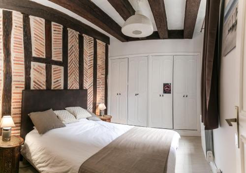 图尔"L'Appart" Vieux Tours - Charme - Place Plumereau - Arrivée Autonome的一间卧室设有一张床和砖墙