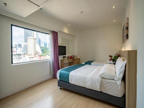 吉隆坡Floresta Hotel Chinatown的一间卧室设有一张床和一个大窗户