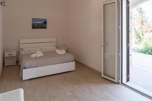 奥特朗托agriturismo masseria pallanzano的一间卧室设有一张床和一个滑动玻璃门