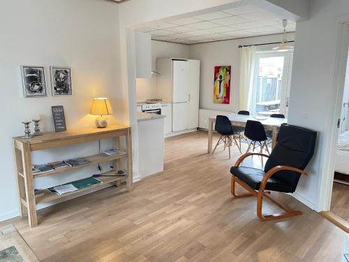 斯凯恩Skjernaa-ferie/ Andersen Invest的一间带桌椅的客厅和一间厨房