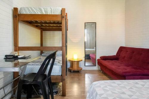 博尼图Casa Victour, localização privilegiada的客房设有床、沙发和书桌。