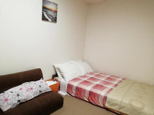 东京Tokyo stay Hut SARI - Vacation STAY 27260v的一间带床和沙发的小卧室