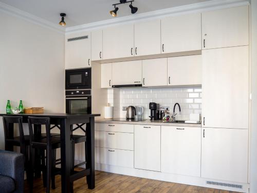 弗罗茨瓦夫Brick House - Apartament Zośka的厨房配有白色橱柜和桌子
