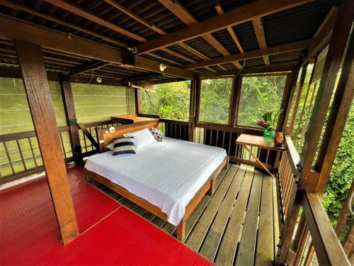 努基La Kuka Hotel - Nuquí的一间卧室,在木甲板上配有一张床