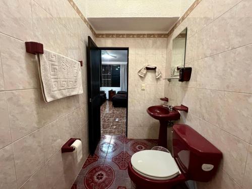 米纳蒂特兰Family queen size的一间带红色卫生间和水槽的浴室