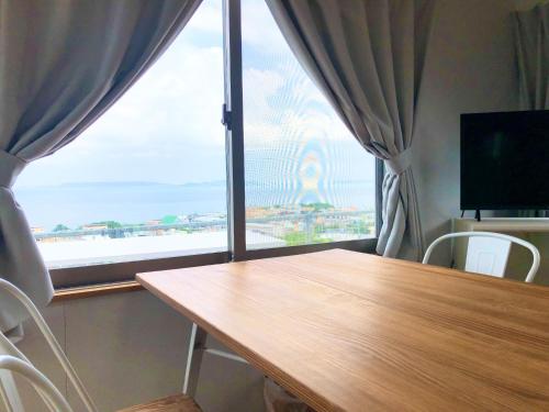 宇流麻Guest House Marine View - Vacation STAY 62152v的一间带桌子和大窗户的用餐室