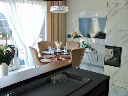 ZB Apartment Luxor Bobrowniki Rogożnik Pyrzowice的一间带桌椅和窗户的用餐室