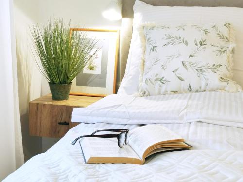 梅尔诺La Ola Apartamenty的一张睡床上的开放式书