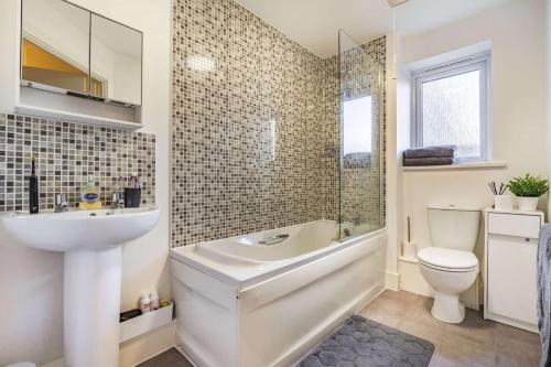 泰恩河畔纽卡斯尔Anox serviced apartment的一间带水槽、浴缸和卫生间的浴室