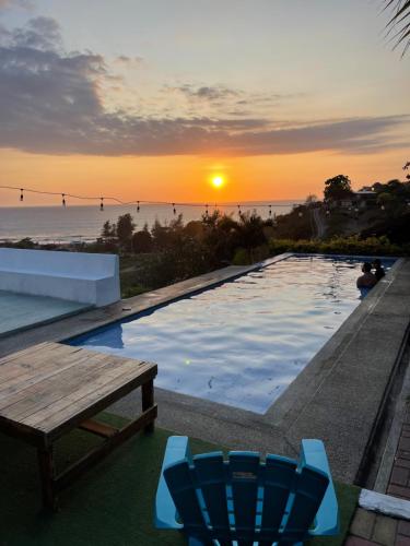 蒙塔尼塔Punta Hills Montanita的游泳池边的日落美景,配有桌椅