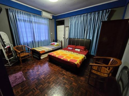 古晋古晋裴特拉贾亚度假屋的一间卧室,卧室内配有一张床和椅子