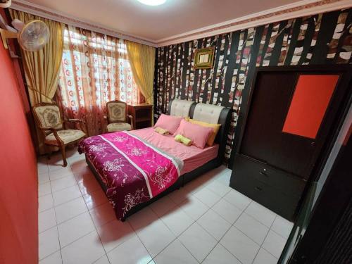 古晋古晋裴特拉贾亚度假屋的一间卧室配有一张带粉色床单的床和一台电视。