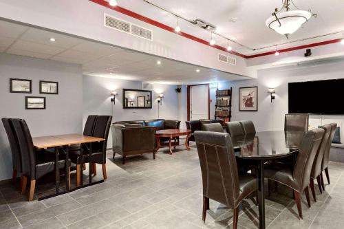 摩城Sure Hotel by Best Western Ole Tobias的用餐室配有桌椅和平面电视。