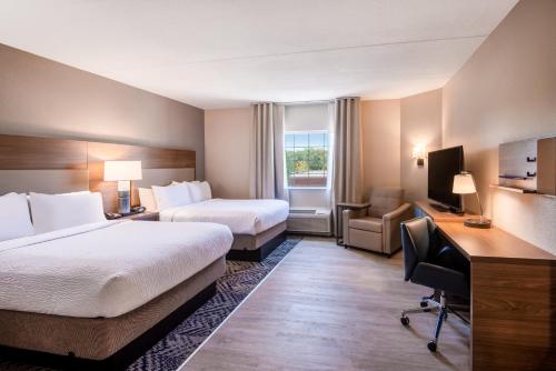 马纳萨斯马纳萨斯烛木套房酒店的酒店客房配有两张床和一张书桌