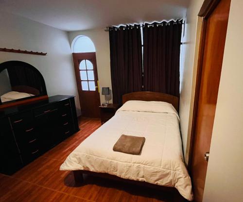 Los Baños del IncaHotel Baños del Inca的一间卧室配有一张床和一个梳妆台