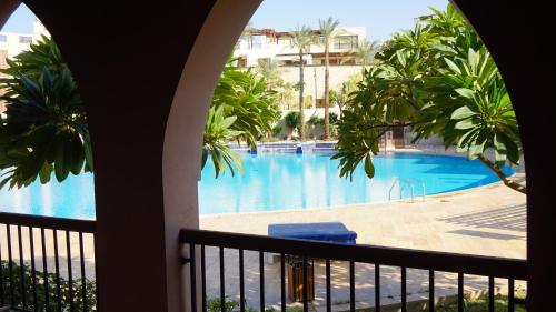 亚喀巴Ground floor apartment by circular pool in Talabay (sweet coffee apartment)的阳台享有游泳池的景致。