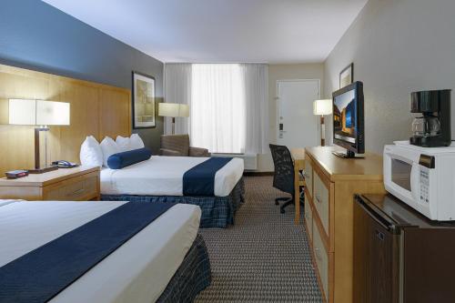 棕榈泉棕榈泉品质旅馆的酒店客房设有两张床和一台平面电视。