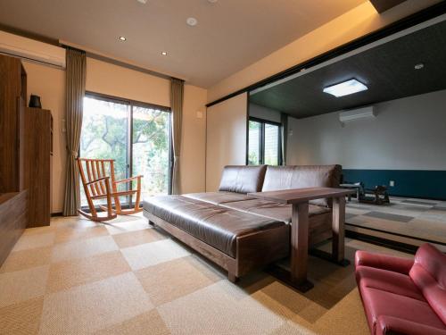 宫岛Bettei Fujiya的卧室配有一张床和一张桌子及椅子