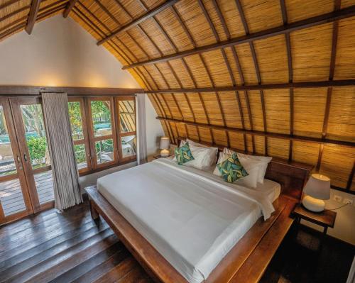 吉利特拉旺安吉利特拉万安 曼塔潜水度假酒店的一间卧室设有一张带木制天花板的大床