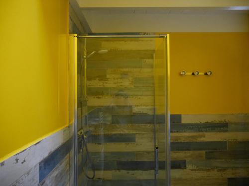 班戈Maison Bangor, 3 pièces, 4 personnes - FR-1-418-215的浴室设有玻璃淋浴间,浴室设有黄色的墙壁