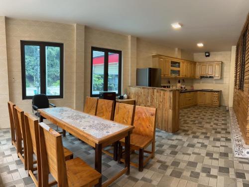 河江Golden Jungle House的厨房以及带桌椅的用餐室。