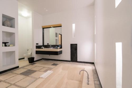 塞米亚克The Seminyak Suite - Private Villa的浴室配有盥洗盆和浴缸。
