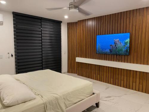 克鲁兹德华纳卡克斯特尔BNayar casa de playa Pescadores 16的一间卧室配有一张床,墙上配有电视