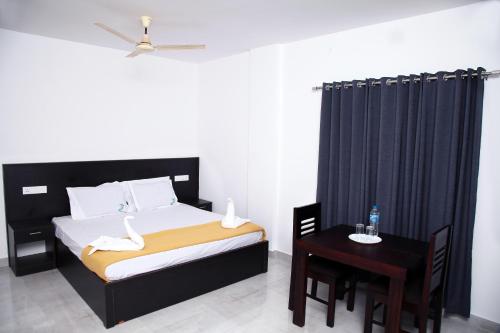 提喀迪Thekkady Travel Rooms的一间卧室配有一张床和一张桌子及椅子