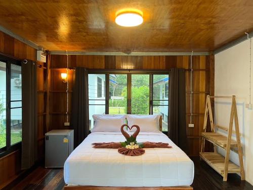 俊穆岛Koh Jum Paradise Resort的一间卧室配有一张带天鹅装饰的床。