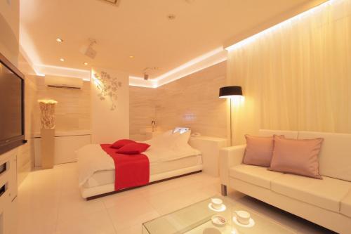 旭川旭川ホテルリップローズ-大人専用的一间卧室配有一张床、一张沙发和一台电视