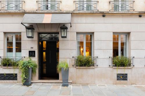 巴黎维拉玛当酒店 的一座有黑色门和盆栽植物的建筑